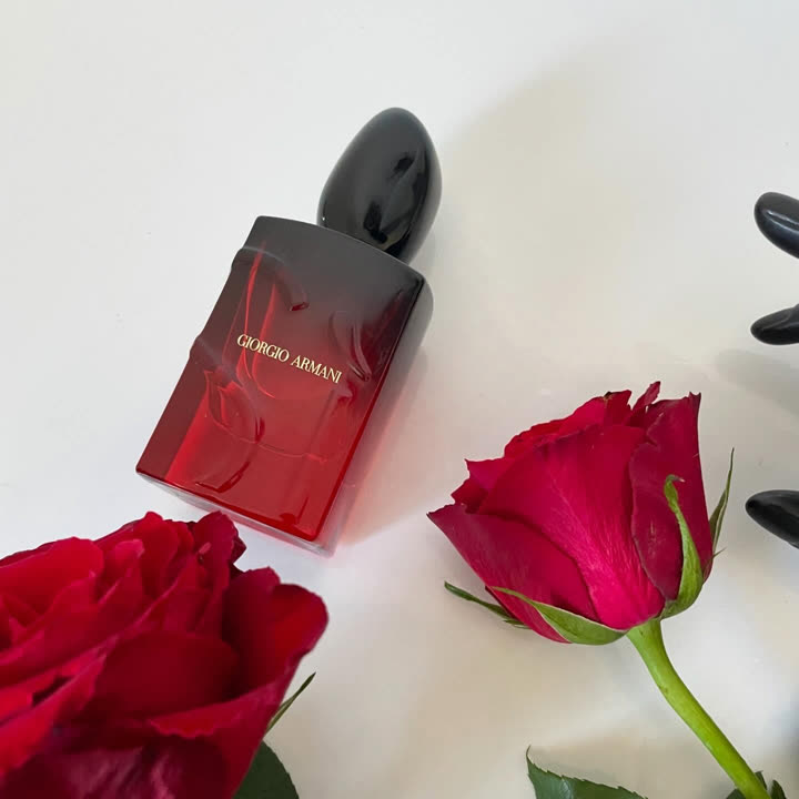 Flacon Sì Passione Eau de Parfum Intense entre deux roses rouges, photographié par une ambassadrice