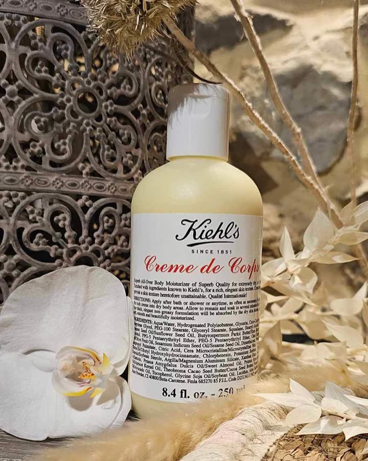 Flacon de Crème de Corps Kiehl’s posé entre des fleurs séchées