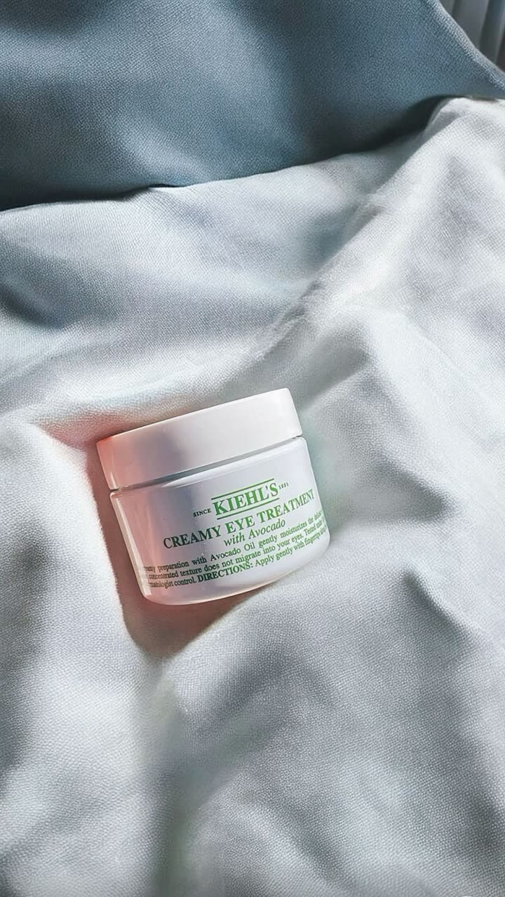 Pot de crème contour des yeux à l’avocat Kiehl’s posé sur des draps, publié pendant la Fashion Week