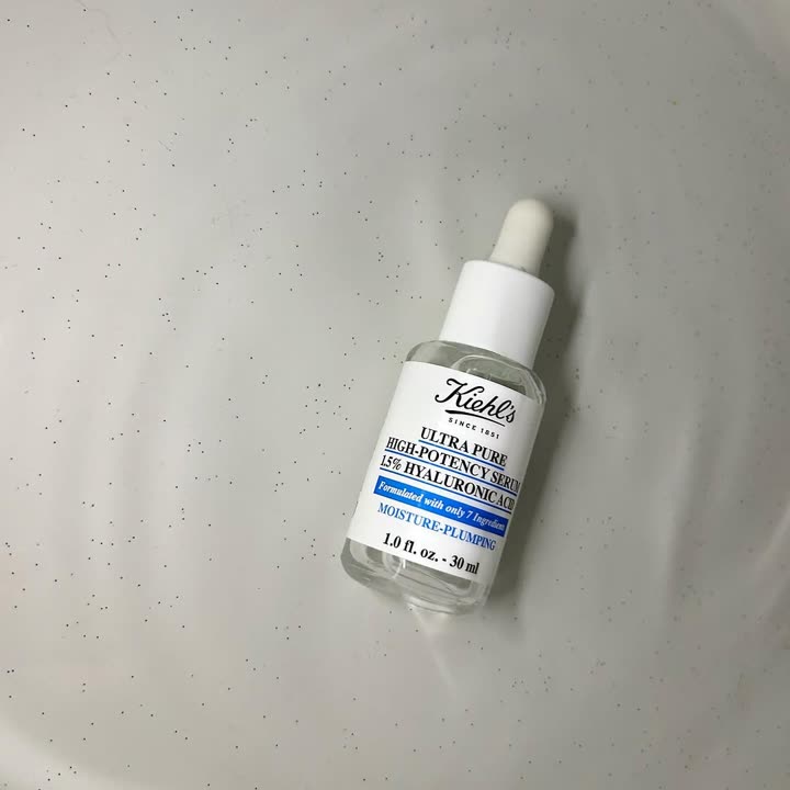 Flacon du sérum Ultra Pure à l’acide hyaluronique de Kiehl’s posé sur un drap pailleté