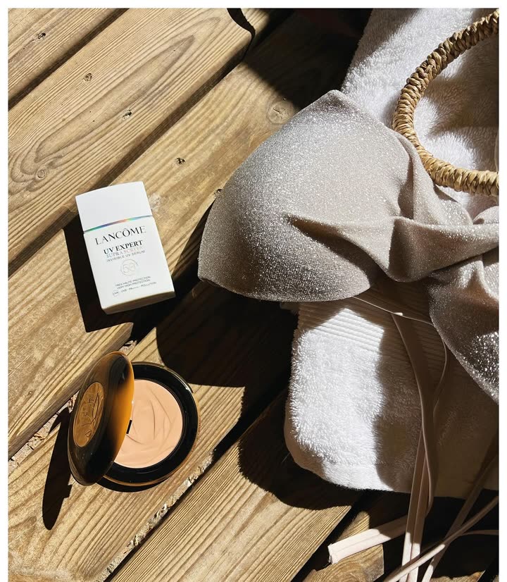 Soin solaire UV Expert et poudre bronzante Teint Idôle de Lancôme posés au soleil
