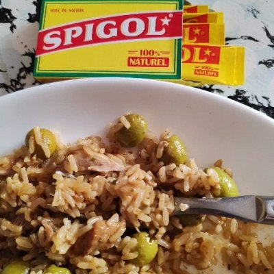 Boîte de Spigol à côté d'une assiette de riz aux olives, photographiée par une ambassadrice